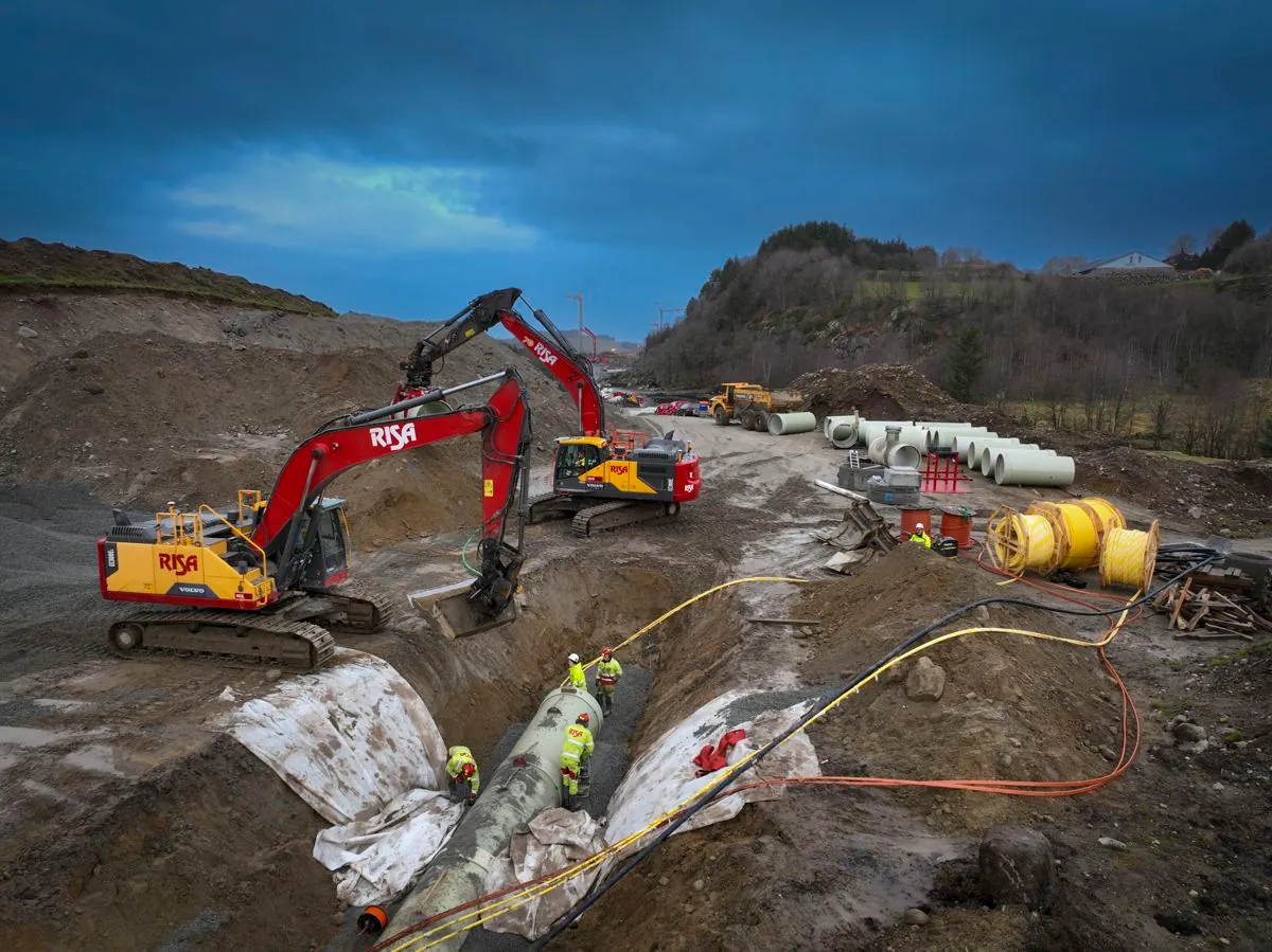 Risa excavators and construction workers installing concrete pipes